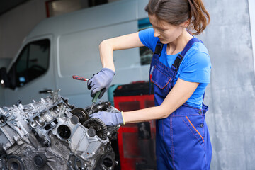 Fototapeta na wymiar Young auto mechanic repairs the engine of a modern car