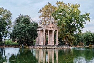 Fototapeta na wymiar Temple of Asclepius situated in the middle of the small island on the artificial lake in Villa Borghese gardens, Rome, Italy