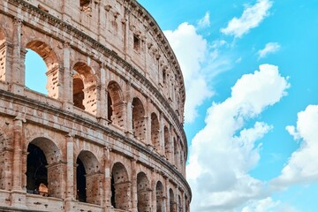 The Colosseum, Architectural wonder of Roman Empire (Colosseo) with blue sky background and clouds,...