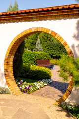 Brick round Japanese arch in the summer garden.