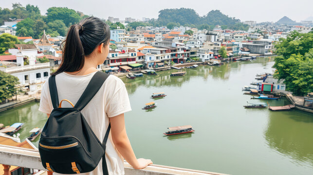 Tourist Overlooking River in Southeast Asian Town