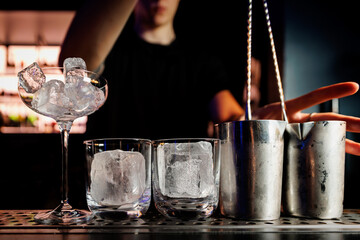 Glasses with ice while preparing an alcoholic cocktail.
