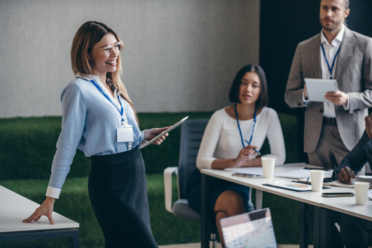 Smiling female speaker talking to audience during a business seminar in convention center