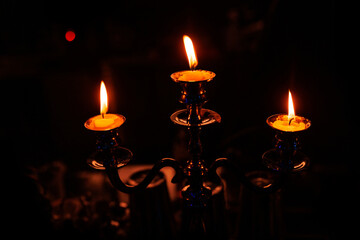 A vintage candelabra with three lit candles.