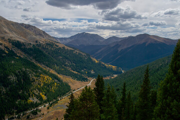 Fototapeta na wymiar Colorado mountain landscape with a road winding through a pine forested valley