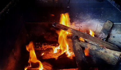 Blurred flame on a barbecue grill. The wood used was made from old tree trunks. Recycling concept.