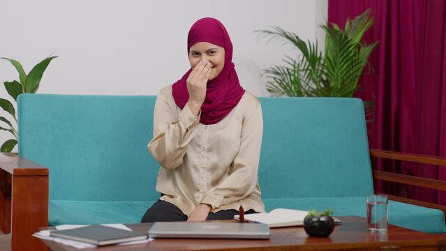 Happy Muslim Woman in Hijab Scarf Sitting on Couch Greeting Adab