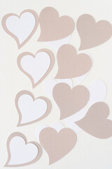 machine-cut beige and white paper hearts on blank paper