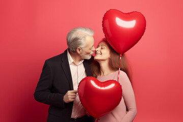 Fototapeta na wymiar Happy Elderly Old Couple With Heart Balloon for Valentines Day Coral Background