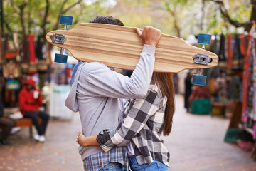 Couple, hide with skateboard and outdoor in city, hug and excited to learn together and romantic relationship. Cape town, touch and hobby with boyfriend and girlfriend in street, love and dating © Miko/peopleimages.com