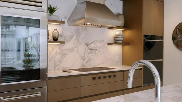 Modern kitchen with steel refrigerator with double door and cabinets matching color scheme of room. Countertop made of high-quality marble with natural patterns