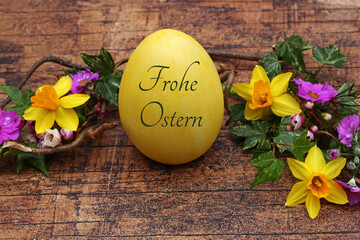 Grußkarte Frohe Ostern: Beschriftetes Osterei mit Blumen und Zweigen.	