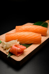 Large salmon pieces on a leaf with ginger and wasabi