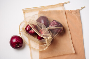 Red apples in a reusable mesh bag.