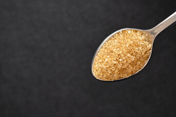 Top view, Teaspoon of brown sugar, Close up of cane sugar copy space for text.