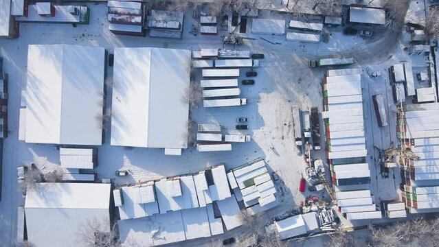 Shipping container and cargo crane at storage yard at winter time aerial view
