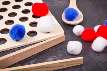 Colorful pompoms using for playing and development of kids motor skills, coordination and logical thinking