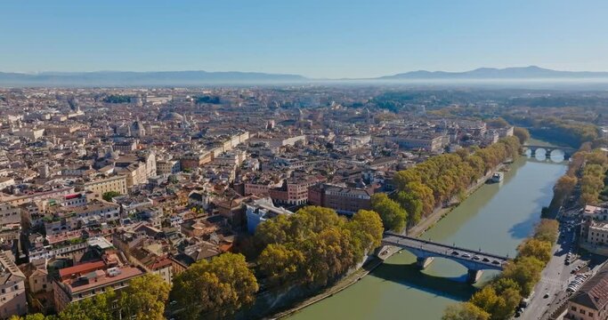 Aerial view of the urban cityscape with the Tiber river in Rome, Italy. Different banks of the river are connected by arched bridges in the historical tourist center of Europe. High quality 4k footage