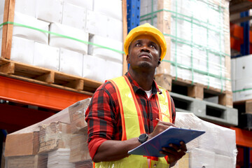 African worker wearing safety vest and helmet, holding file folder document at warehouse factory....