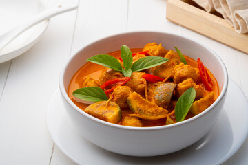 Red curry with clown featherback fishball in white bowl (Gaeng Kua Look Chin pla)