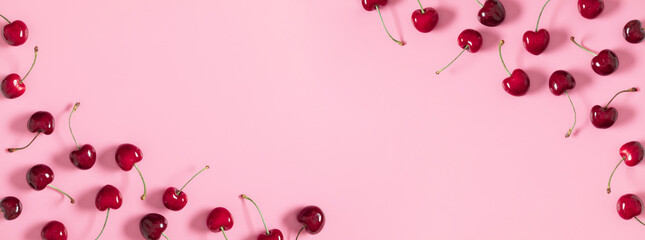 Red cherry on pink background. Ripe red cherry berries as background. Flat lay, top view, copy space