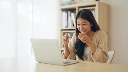 Funny euphoric young asian woman celebrating winning or getting ecommerce shopping offer on computer laptop. Excited happy girl winner looking at notebook celebrating success