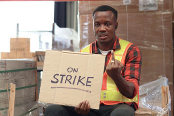 Angry unhappy African worker man wearing safety vest and giving the middle finger with strike...