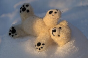 Nadelgefilzter kleiner Eisbär spielt im Schnee