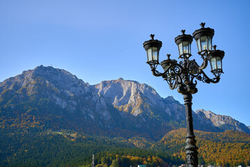 Sunset mountain range with a decorative iron lamp post near the town of Busteni, Transylvania,...
