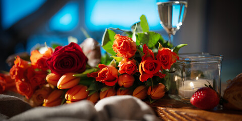 Romantic still life with red roses and tulips, champagne and candlelight. Background concepts for...