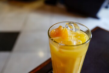 氷とみかんの果肉が入った冷たいオレンジジュース