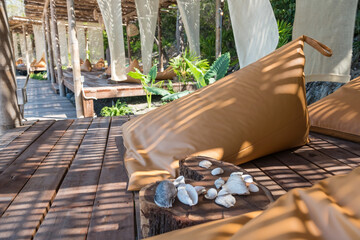 brown beanbags with decorated shell in outdoor beach cafe
