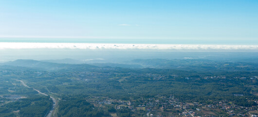 Aerial view of a natural park with ocean and clouds.