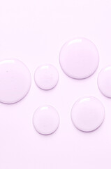 Pink drops of moisturizing gel or serum. Cosmetic product for skin care. Copy space.