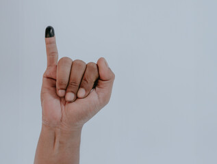 Inked pinky finger. Man hand isolated on white background. Purple ink blots from voters finger...