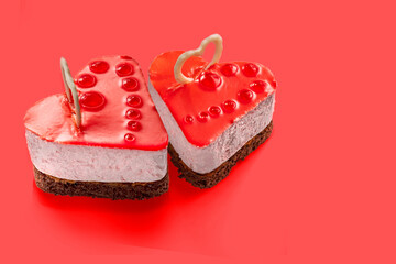 Red glazed cheese cake in the shape of a heart with fruit jelly decoration. Exquisite Fresh delicious mousse dessert.