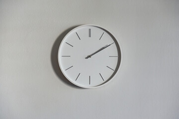 Wall clock white color minimal design on white wall.