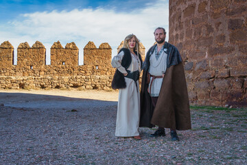 Couple in Medieval Attire by Fortress Ruins