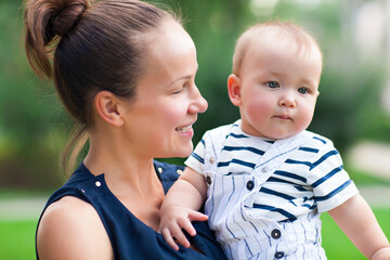 Happy mum and her child playing in park together