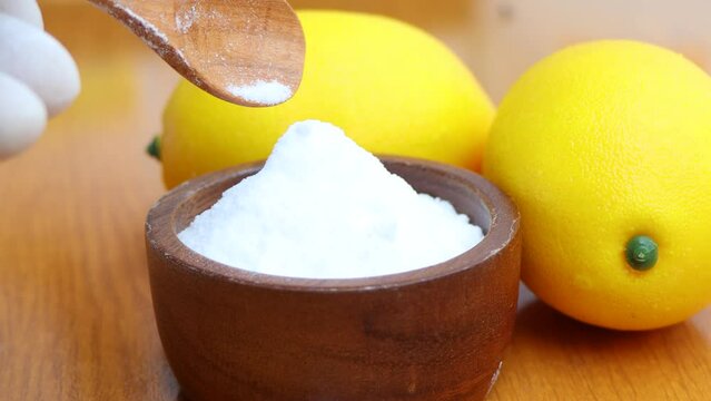 Citric acid white powder, Lemon extract is used as raw material, wood background 