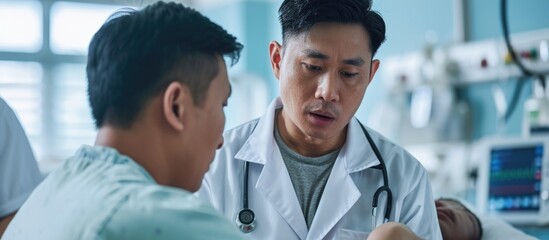 Asian doctor examining male patient in hospital.