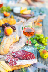 Picnic with rose wine fruits meat and cheese