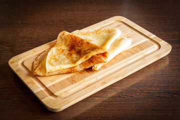 Traditional pancakes on a wooden board.