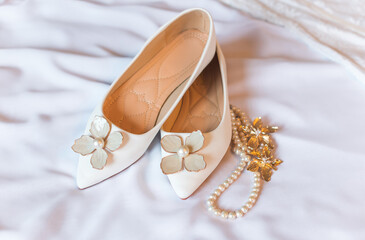 Weddings women white shoes with no heels with a flowers and pearls. Concept of Wedding, accessorize