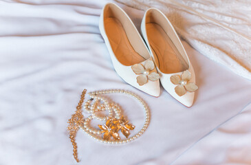 Weddings women white shoes with no heels with a flowers and pearls. Concept of Wedding, accessorize