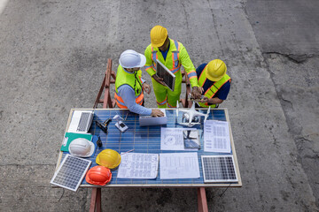 Foreman or worker work at Container cargo site. Architectural engineer working, meeting, planning with blueprint, Solar photovoltaic equipment and wind turbine