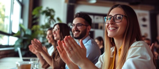 Content business team applauding and facing camera in contemporary workspace.