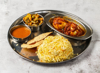 Boiled egg biryani thali set with gravy, mixed vegetable of aloo gobi matar, nachos and shorba served in dish isolated on background top view of indian spicy food