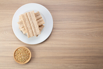Obraz na płótnie Canvas Buckwheat crisp bread and buckwheat on plate on wooden background, gluten free. Dietary cookies