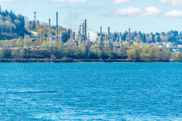 refinery plants generating smokes on the ocean background